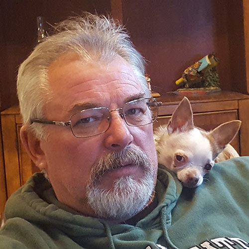 portrait of John with a chihuahua dog cuddling on his shoulder